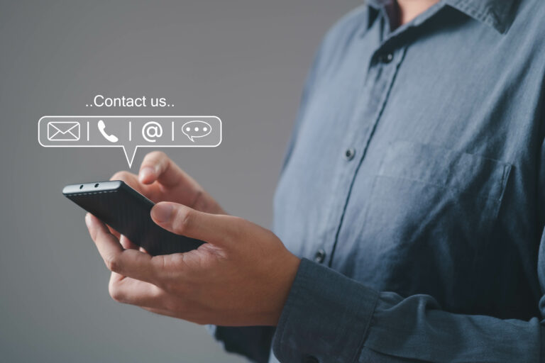 A person holding a smartphone, showcasing contact options like email, phone, and messaging for easy communication